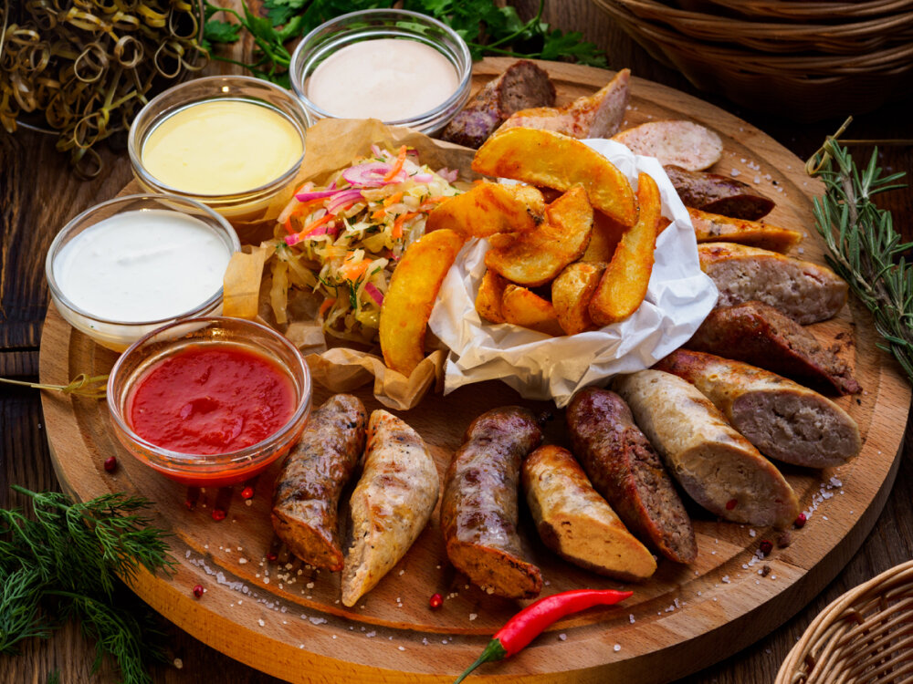 Пивная тарелка с колбасами: 4 вида колбас с квашенной капустой, дольками картохи и 4 соусами