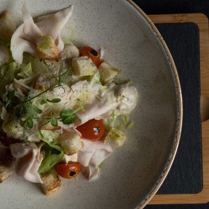 Салат с куриной грудкой, салатными листьями, соусом цезарь и молодыми томатами